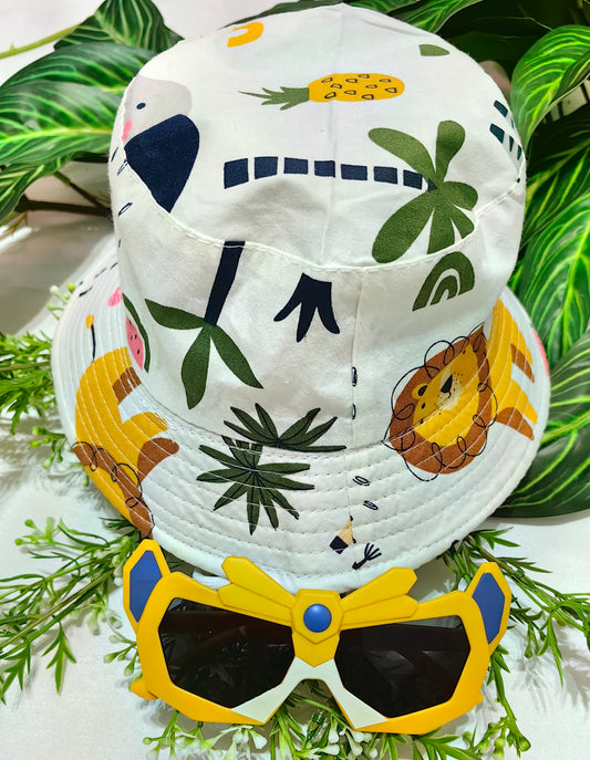 Children's bucket hat with animal prints and sunglasses on a green leaf background